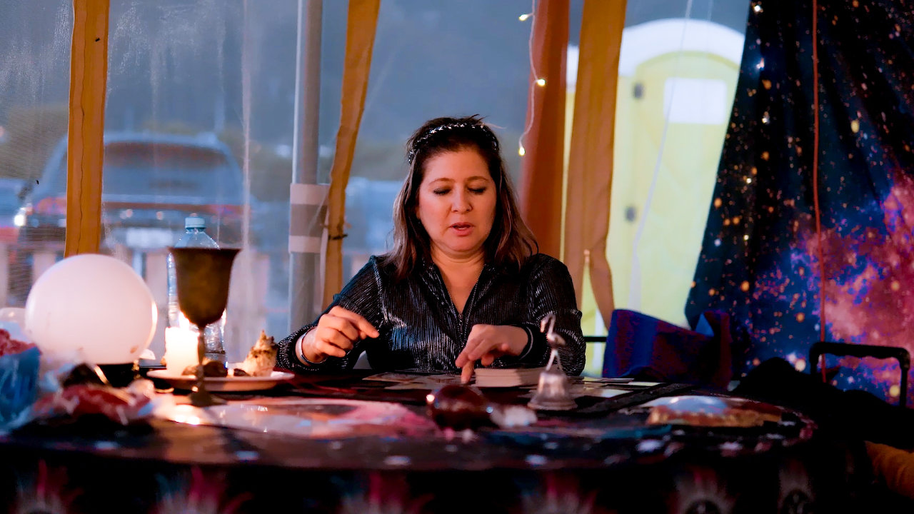 Dos mujeres con una bruja practicando Tarot